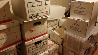 Storage room at the Refugee Resettlement Office with boxes and cabinets containing stacke from floor to ceiling. Photo courtesy the Archives of The Episcopal Diocese of Olympia.
